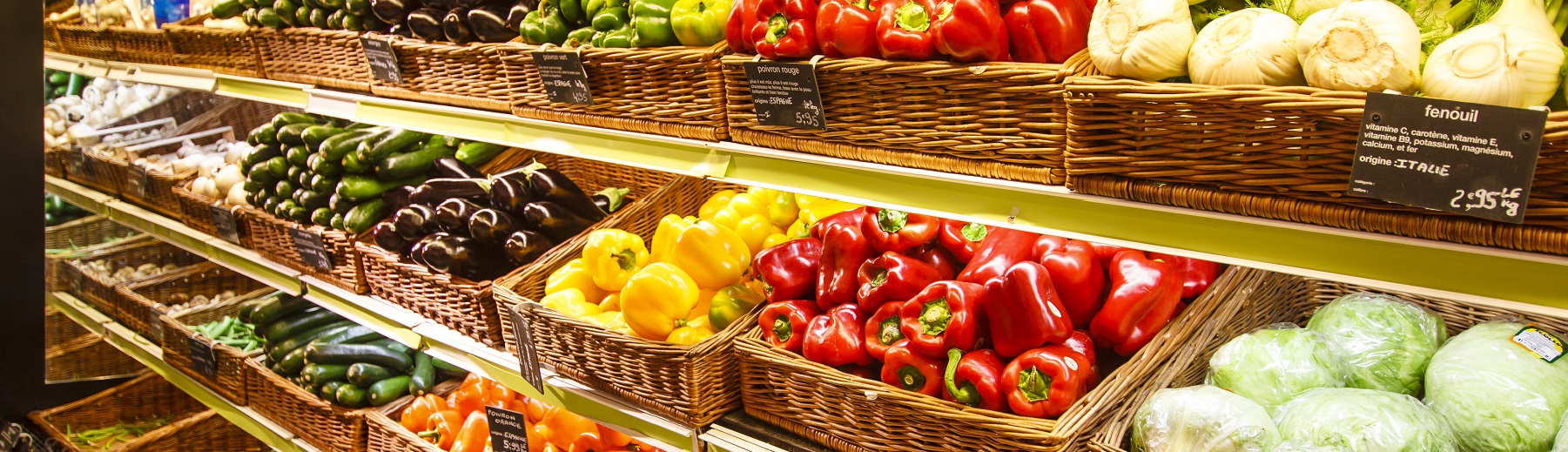 Many types of fresh produce in baskets on shelves