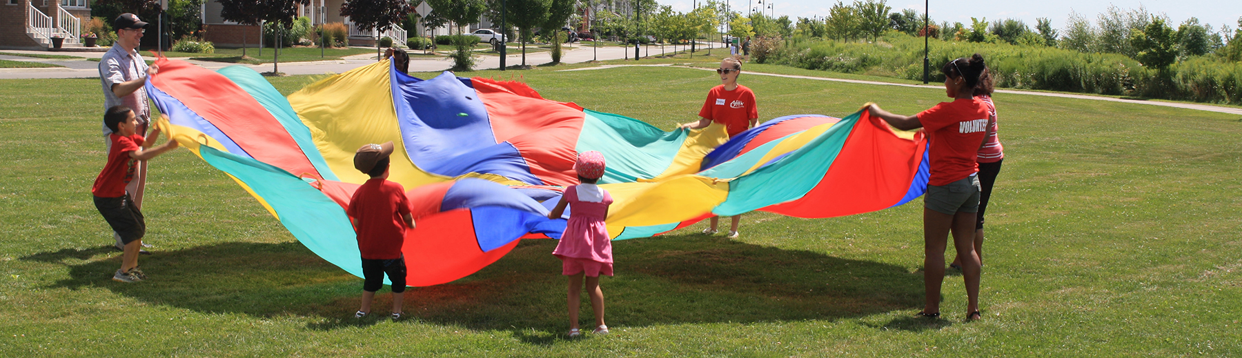 Children play with a large flag in a park
